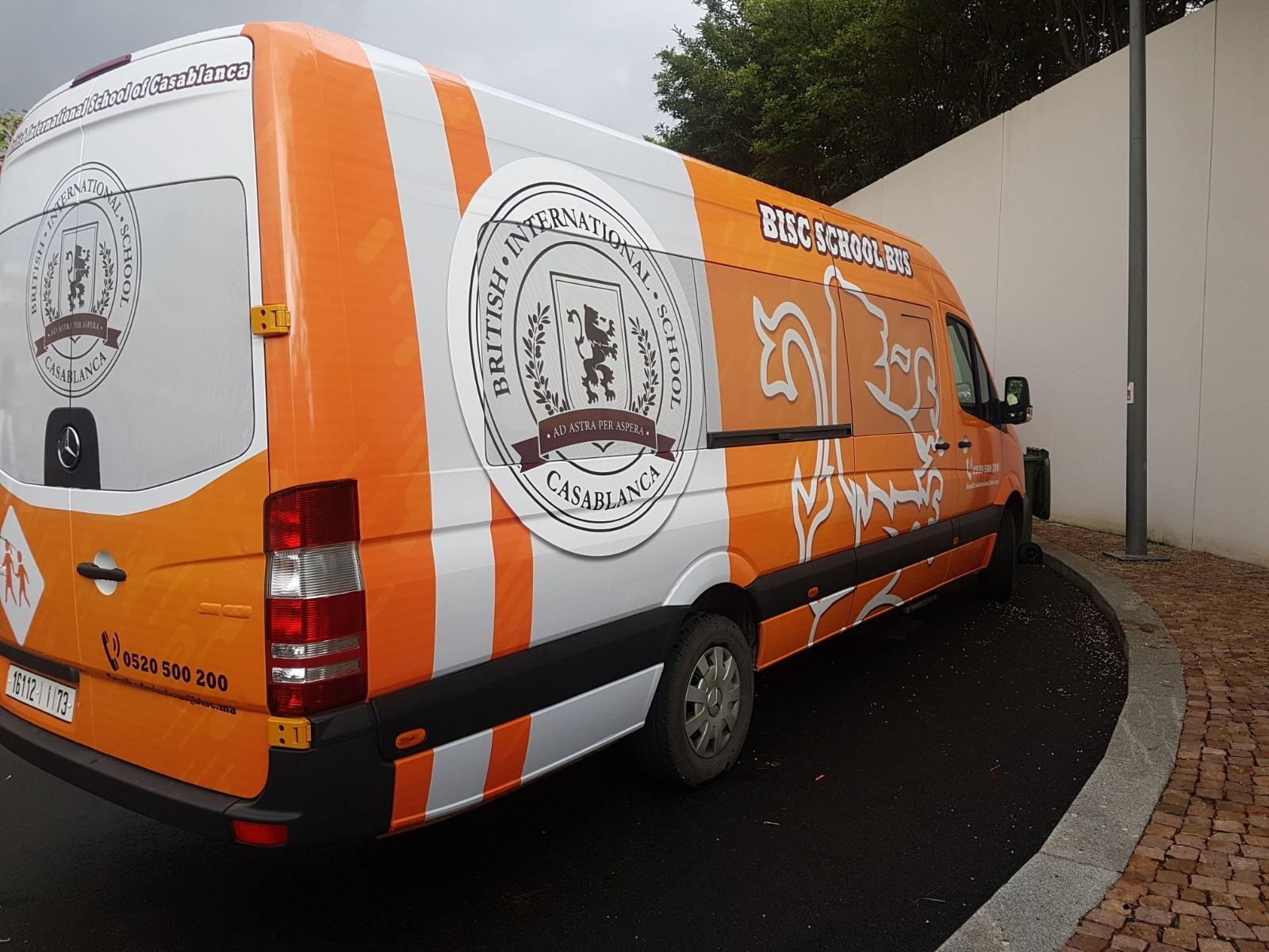 Minibus scolaire habillé d’un visuel orange et blanc