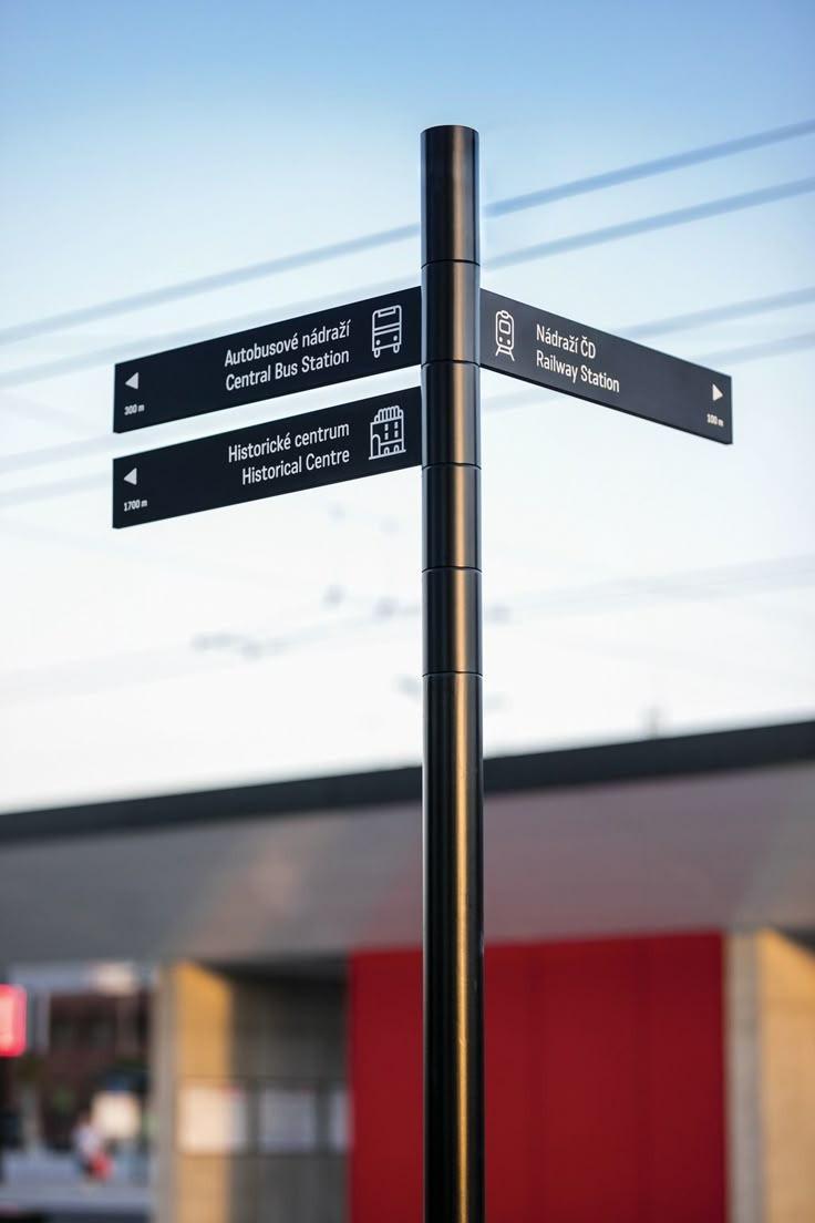 Signalétique directionnelle noire sur poteau en extérieur